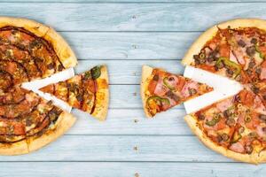 deux différent délicieux gros pizzas sur une bleu en bois Contexte photo