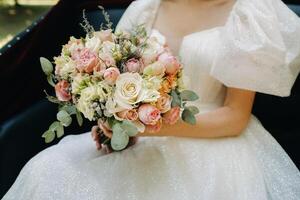 une magnifique mariage bouquet avec des roses dans le mains de le la mariée photo