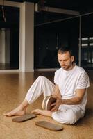 une homme détient dans le sien mains planches avec ongles pour yoga Des classes photo