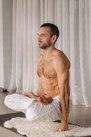 une homme avec une nu torse Est-ce que yoga dans une aptitude chambre. le concept de une en bonne santé mode de vie photo