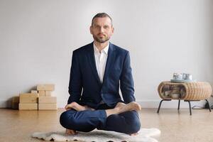 une homme dans une strict costume Est-ce que yoga tandis que séance dans une aptitude pièce photo