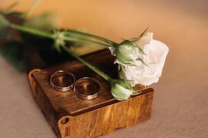 designer mariage anneaux mensonge sur le surface avec une Rose. deux mariage anneaux photo