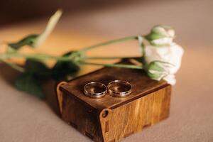 designer mariage anneaux mensonge sur le surface avec une Rose. deux mariage anneaux photo