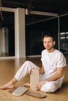 une homme détient dans le sien mains planches avec ongles pour yoga Des classes photo