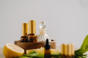 essentiel pétrole dans bouteilles avec citron et menthe fragrance mensonge sur une en bois surface photo