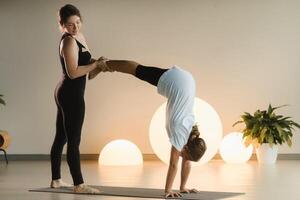 maman et adolescent fille faire gymnastique ensemble dans le aptitude chambre. une femme et une fille train dans le Gym photo