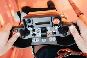 éloigné contrôle de une levage voiture grue dans le mains de une personne. panneau avec joysticks et boutons pour contrôler le télescopique seau de le grue. photo