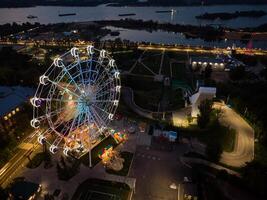 magnifique le coucher du soleil plus de le ville avec une éclairé ferris roue. photo