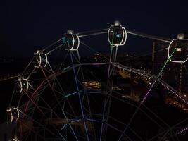 magnifique le coucher du soleil plus de le ville avec une éclairé ferris roue. photo