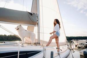 une content femme avec une gros blanc chien sur une blanc yacht dans le mer photo