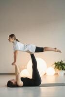 maman et adolescent fille faire gymnastique ensemble dans le aptitude chambre. une femme et une fille train dans le Gym photo