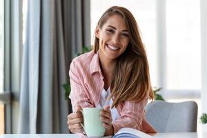 Jeune affaires femmes dans le Bureau en buvant café et à la recherche à le caméra photo