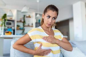 jeune femme caucasienne palpant sa poitrine par elle-même qu'elle s'inquiète du cancer du sein. concept de soins de santé et de cancer du sein photo