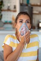 malade femme fabrication inhalation, médicament est le meilleur médicament. mauvais femme portant un oxygène masque et subissant traitement pour COVID-19 [feminine. femme avec un inhalateur photo