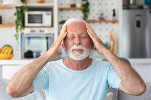 mal de tête. Sénior homme Souffrance de migraine douleur masser les temples séance à maison. soins de santé, santé problèmes dans plus âgée âge concept photo