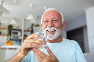 Sénior homme boisson l'eau de verre. bien santé, mode de vie. photo