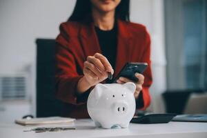 femme d'affaires enregistrer argent dans porcin banque et objectif et réussite graphique graphique et flèches. fonds prêts et investissement bénéfices. concept de économie pour assurance, santé, éducation, loger, voiture, impôt, prêt photo