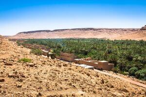 une village à un oasis à le bas de une canyon dans le atlas montagnes, Maroc photo