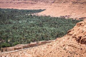 une village à un oasis à le bas de une canyon dans le atlas montagnes, Maroc photo