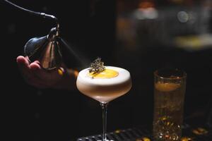 le barman prépare une magnifique alcoolique cocktail à le bar compteur photo