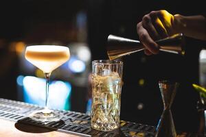 le barman prépare une magnifique alcoolique cocktail à le bar compteur photo