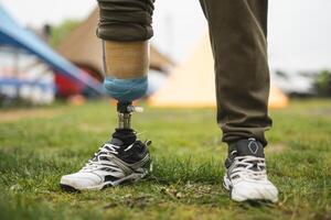 une homme avec une prothétique jambe est Faire des sports en jouant Football photo