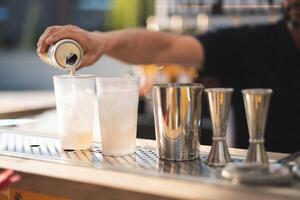 le barman derrière le bar fait du un alcoolique cocktail photo