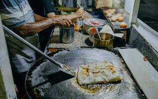 fabrication processus de Martabak telor. sarriette poêlé Pâtisserie farci avec œuf, Viande et épices. Martabak est populaire prendre une façon nourriture parmi malais ou indonésien. photo