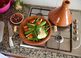 vue de au dessus de une délicieux végétarien repas de en bonne santé biologique légumes à la vapeur dans argile plat - marocain tajine photo