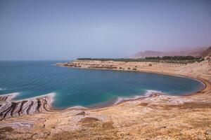 vue de mort mer littoral à le coucher du soleil temps dans Jordan. sel cristaux à le coucher du soleil. mort mer paysage avec minéral structures. photo