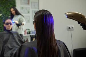 portrait de une magnifique femme avec longue marron tout droit cheveux dans une beauté salon. photo