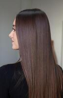 portrait de une magnifique femme avec longue marron tout droit cheveux dans une beauté salon. photo