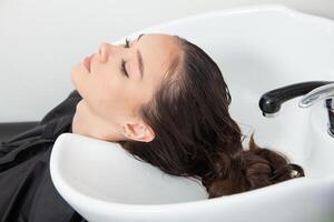 portrait de une magnifique femme avec longue marron tout droit cheveux dans une beauté salon. photo