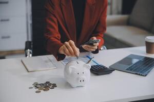 femme d'affaires enregistrer argent dans porcin banque et objectif et réussite graphique graphique et flèches. fonds prêts et investissement bénéfices. concept de économie pour assurance, santé, éducation, loger, voiture, impôt, prêt photo