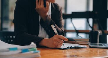 asiatique femme d'affaires travail sur portable à le Bureau avec les documents sur le sien bureau, Faire Planification en cours d'analyse le financier rapport, affaires plan investissement, la finance une analyse concept photo