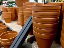 piles de terre cuite argile des pots pour les plantes pour vente à une jardin magasin. photo