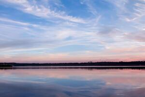 serein des eaux une bienheureux réflexion de une magnifique pastel Lac et ciel, où tranquillité se rencontre la nature palette, création une harmonieux oasis de doux teintes et éthéré beauté photo