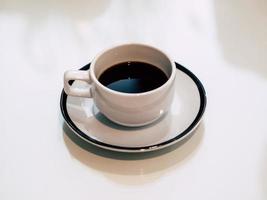 café chaud dans une tasse blanche servi dans un café très calme.