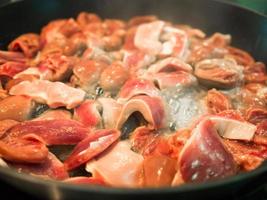 cuisine asiatique cuit coeurs de poulet frits dans une poêle. photo