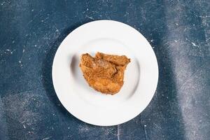croustillant frit poulet pièce dans une assiette isolé sur marbre Contexte Haut vue vite nourriture photo