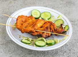 poulet tikka Sein pièce servi dans assiette isolé sur gris Contexte Haut vue de pakistanais et Indien épices nourriture photo