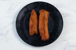 Profond frit brinjal pakora ou commencé servi dans une plat isolé sur Contexte Haut vue de Indien et bengali nourriture photo
