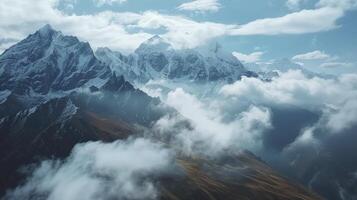 ai généré majestueux enneigé montagnes, imposant pics enveloppé dans des nuages, évoquant une sens de grandeur et sérénité. photo