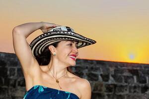 magnifique femme portant le traditionnel colombien chapeau appelé sombrero vueltiao à le historique des rues de le Carthagène de Indes fortifiée ville photo