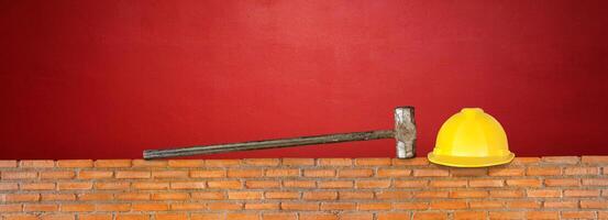 chapeau et marteau sur rouge brique mur rouge ciment Contexte photo