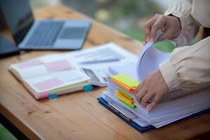 secrétaire est recherche par pile de important les documents sur Bureau table livrer leur à directeur pour présentation dans temps à réunion. concept de difficulté découverte information de piles de document photo