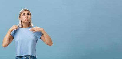 fille sentiment malaise de chaleur permanent plus de bleu Contexte dans fug respiration en dehors et renfrogné à la recherche en haut à Soleil Souffrance de chaud temps agitant avec T-shirt à cool photo