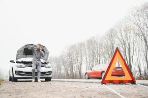 triste chauffeur appel voiture service, ouverture capot, ayant moteur problème permanent près cassé voiture sur le route. voiture panne concept photo