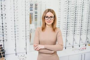 jolie Jeune femme est choisir Nouveau des lunettes à optique magasin. photo