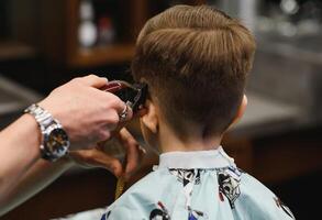 de bonne humeur caucasien garçon avoir coiffure dans salon de coiffure photo